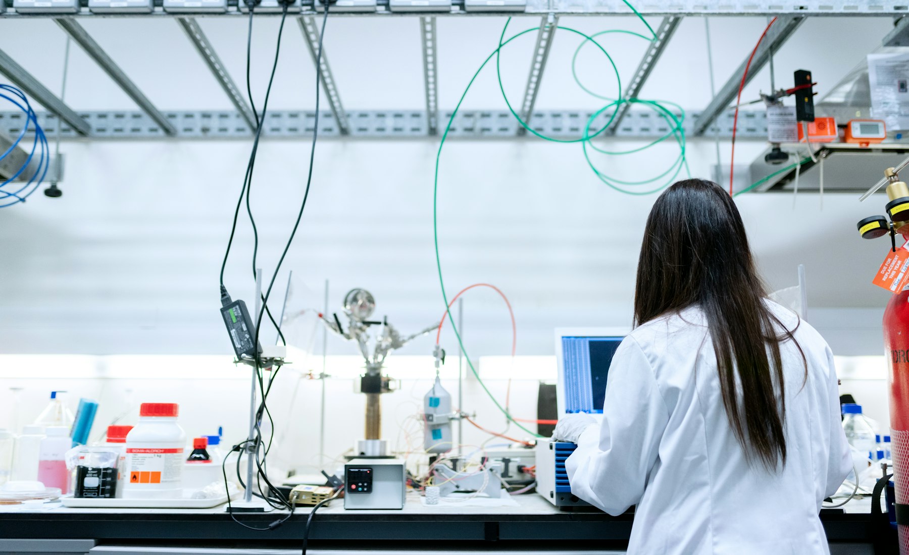 A scientist working at an instrument bench in a bright modern laboratory
